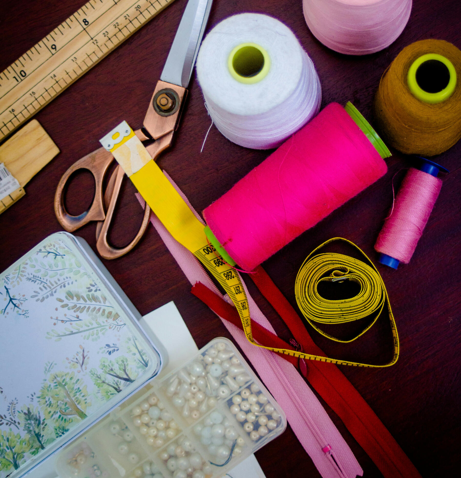 Tools of the trade at Magic Hands Alterations Colorful sewing supplies including thread, scissors, measuring tape and fabric.